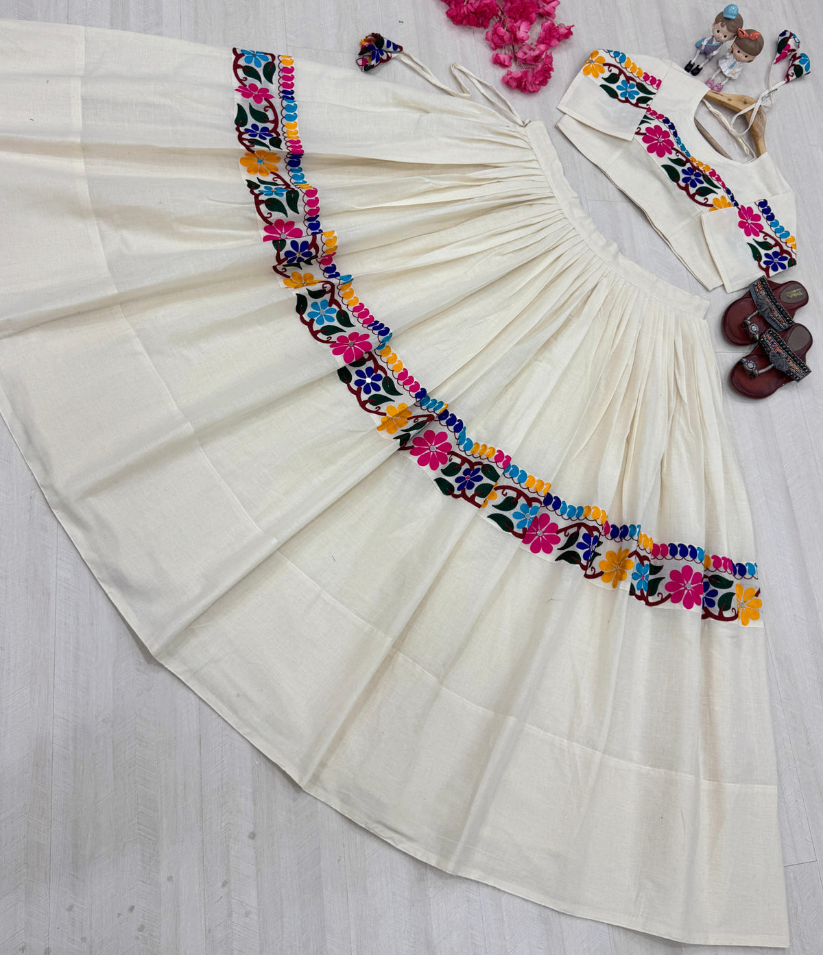 Off-white Navratri lehenga with mirror work border, flat lay