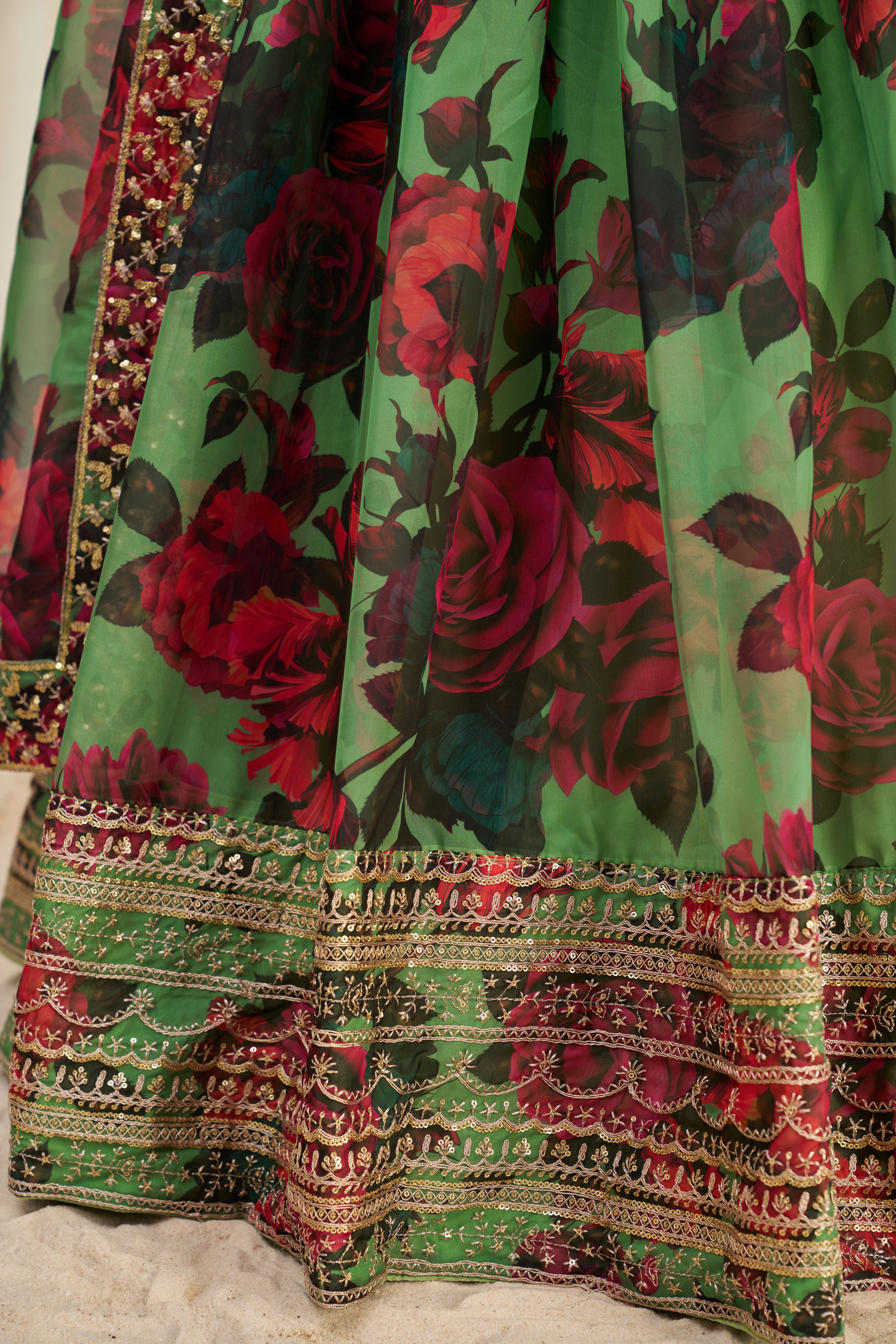 Lehenga Choli Set Features A Vibrant Green Base With Bold Red Floral Patterns