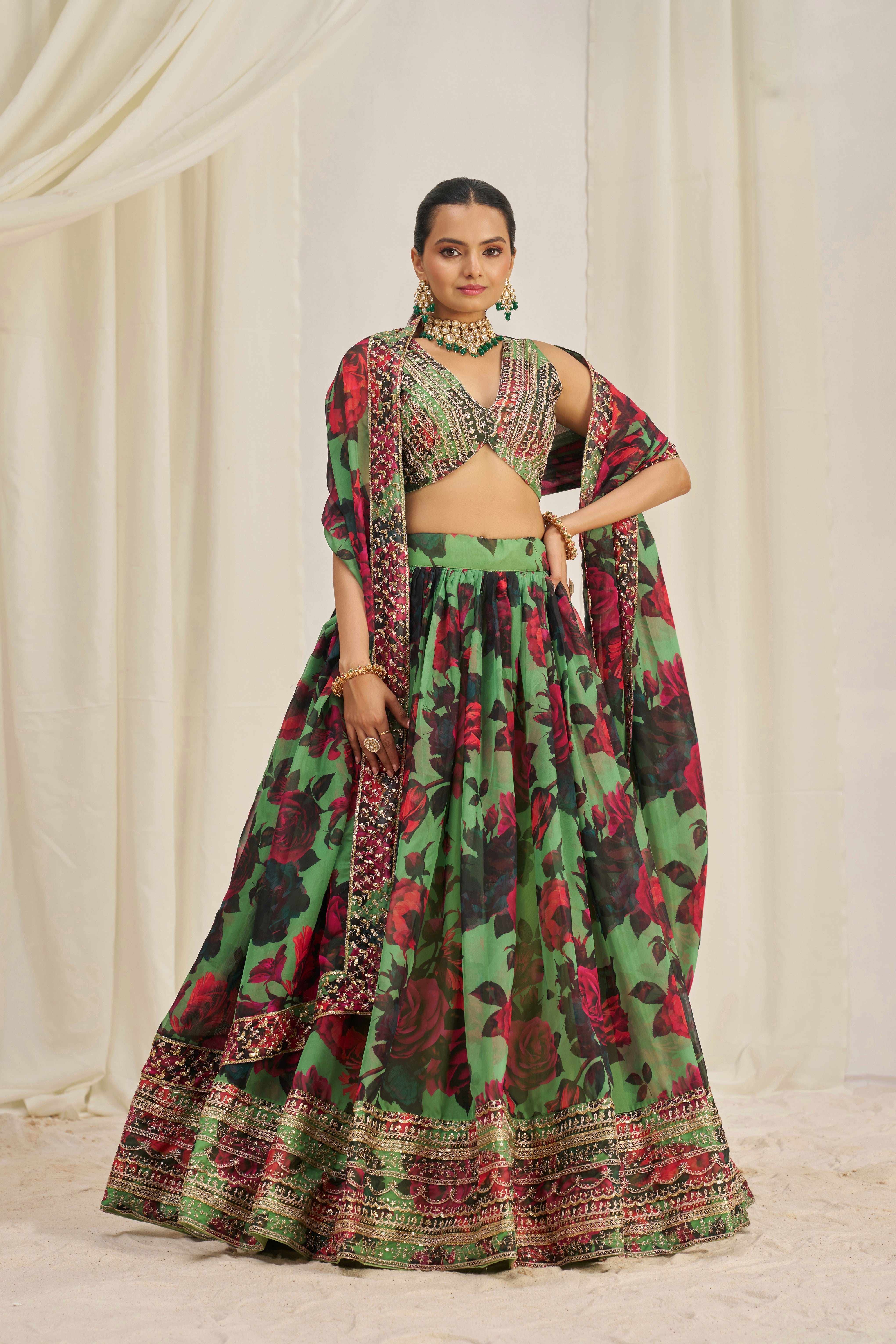 Lehenga Choli Set Features A Vibrant Green Base With Bold Red Floral Patterns