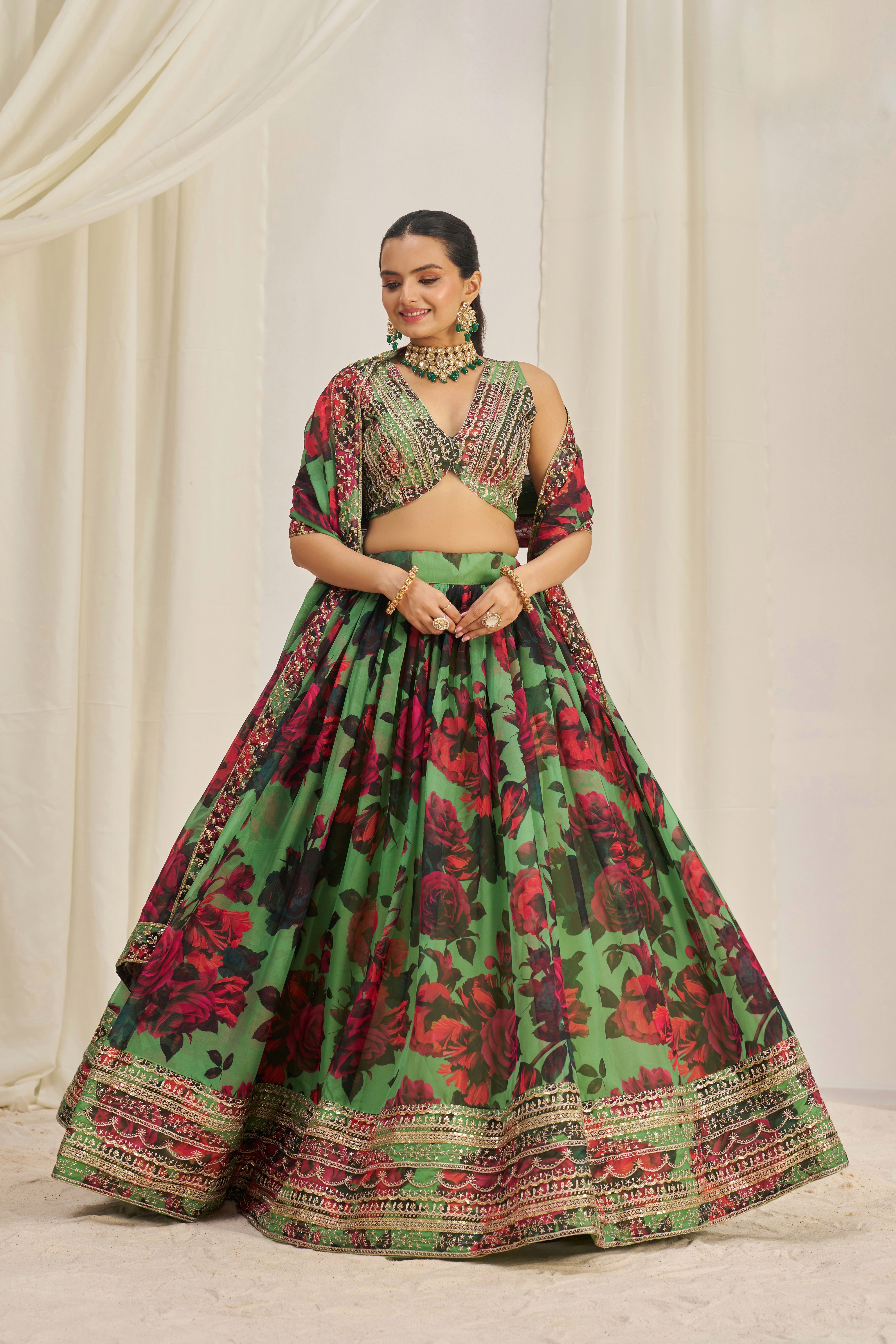 Lehenga Choli Set Features A Vibrant Green Base With Bold Red Floral Patterns