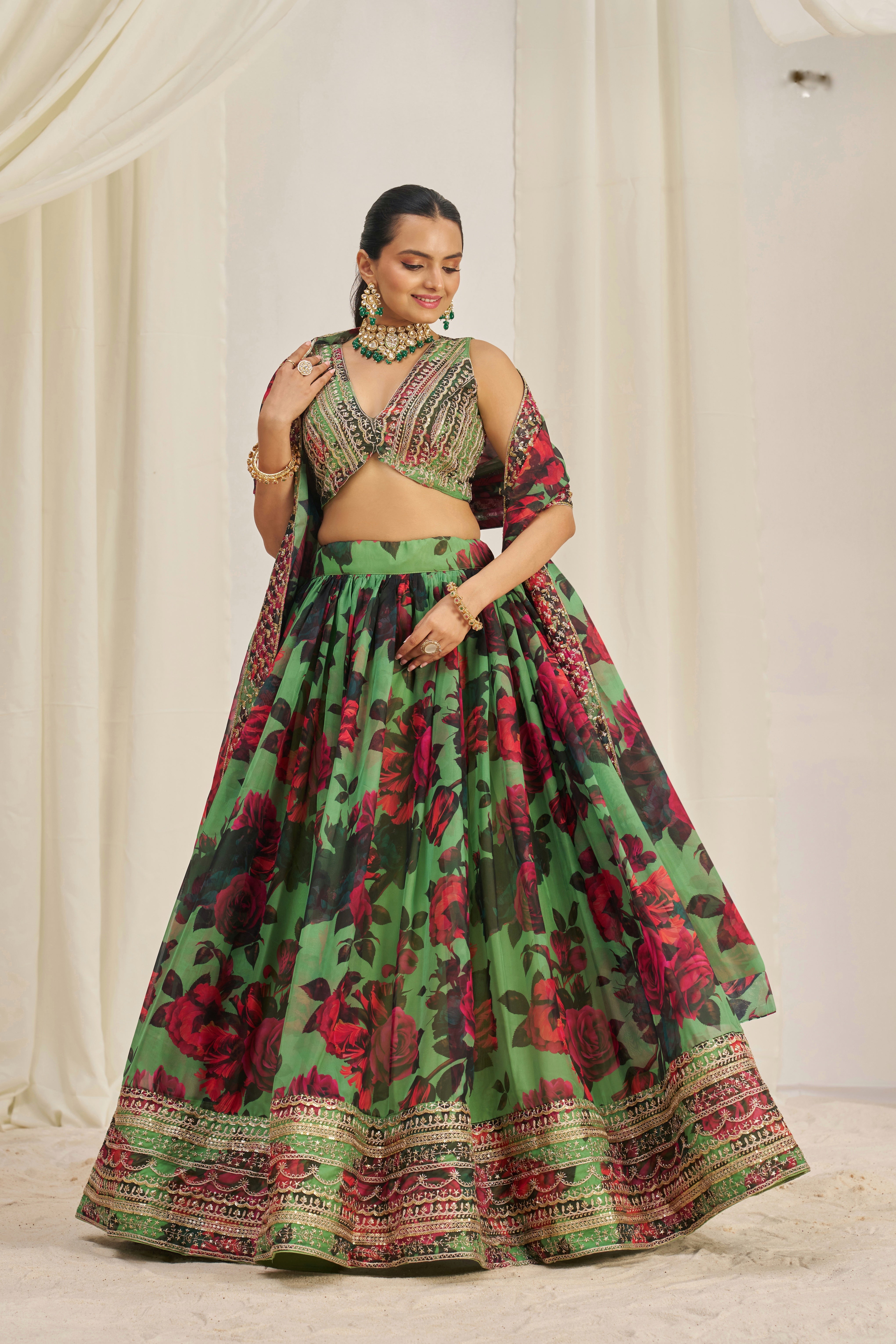 Lehenga Choli Set Features A Vibrant Green Base With Bold Red Floral Patterns