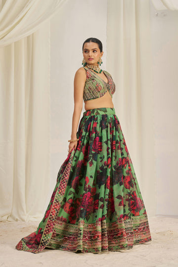 Lehenga Choli Set Features A Vibrant Green Base With Bold Red Floral Patterns