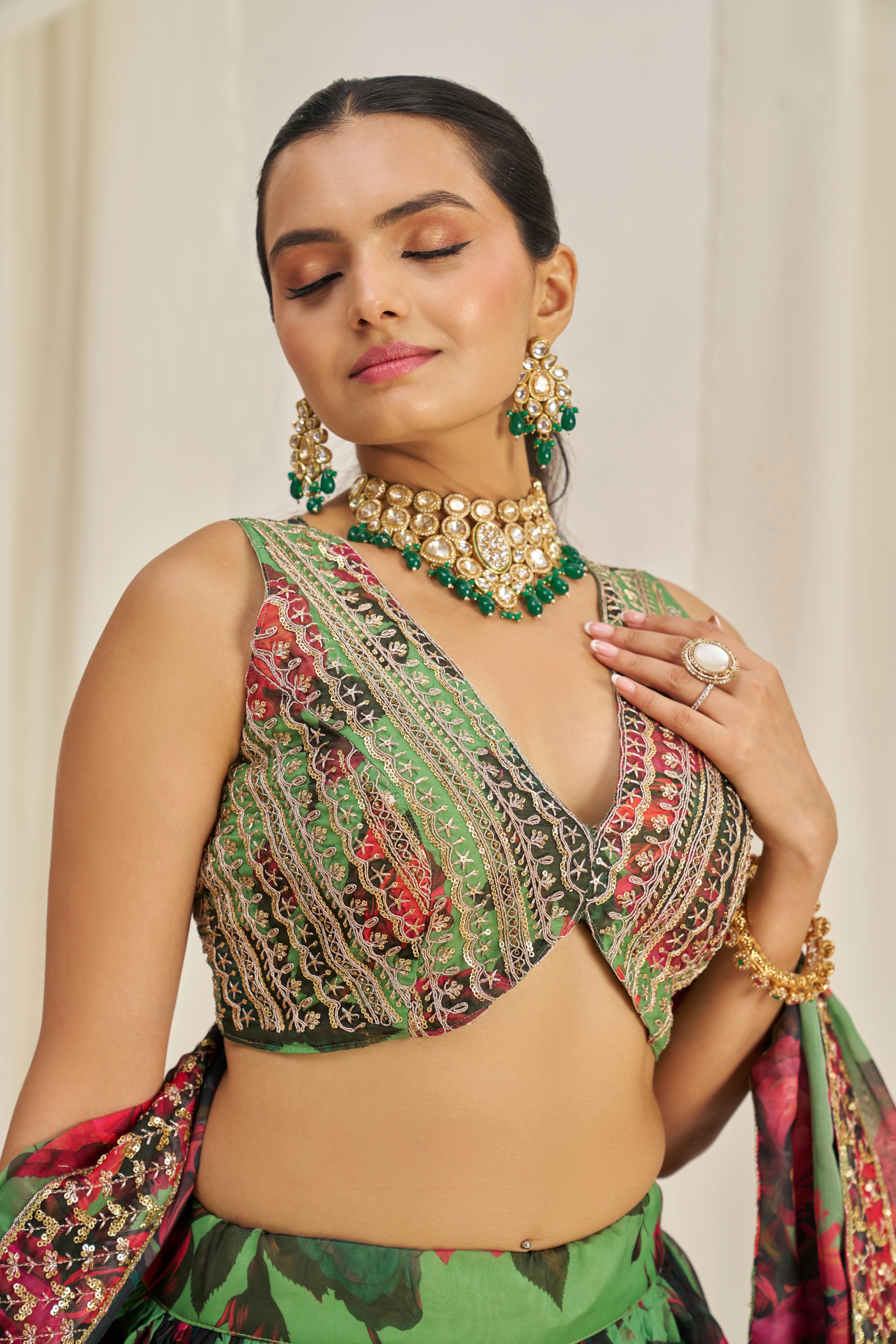 Lehenga Choli Set Features A Vibrant Green Base With Bold Red Floral Patterns